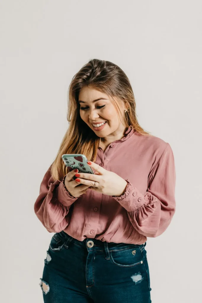 Indépendante souriante qui consulte ses réseaux sociaux sur son smartphone
